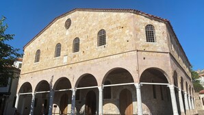 A historic building with a stone facade, multiple arched windows, and a tiled roof. - Macide Hanim Konagi (Ayvalik)