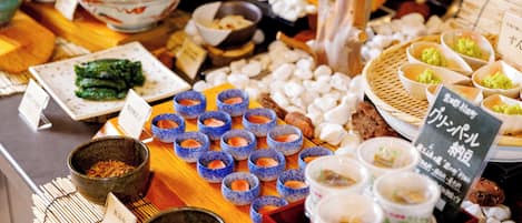 A variety of food items displayed on a wooden table, including bowls of different sizes and shapes, some with labels.