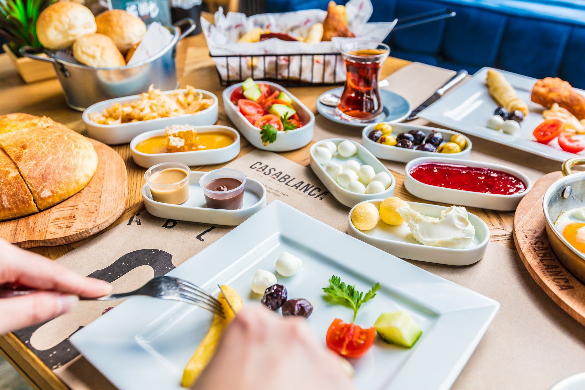Variedad de alimentos en una mesa, incluyendo pan, aceitunas y salsas.