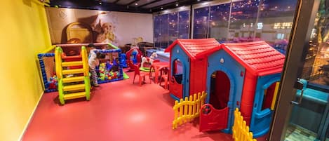 A children's play area with colorful play structures, a ball pit, and a ladder.
