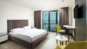 Une chambre d’hôtel moderne équipée d’un grand lit, d’un bureau, d’une chaise et d’une télévision.