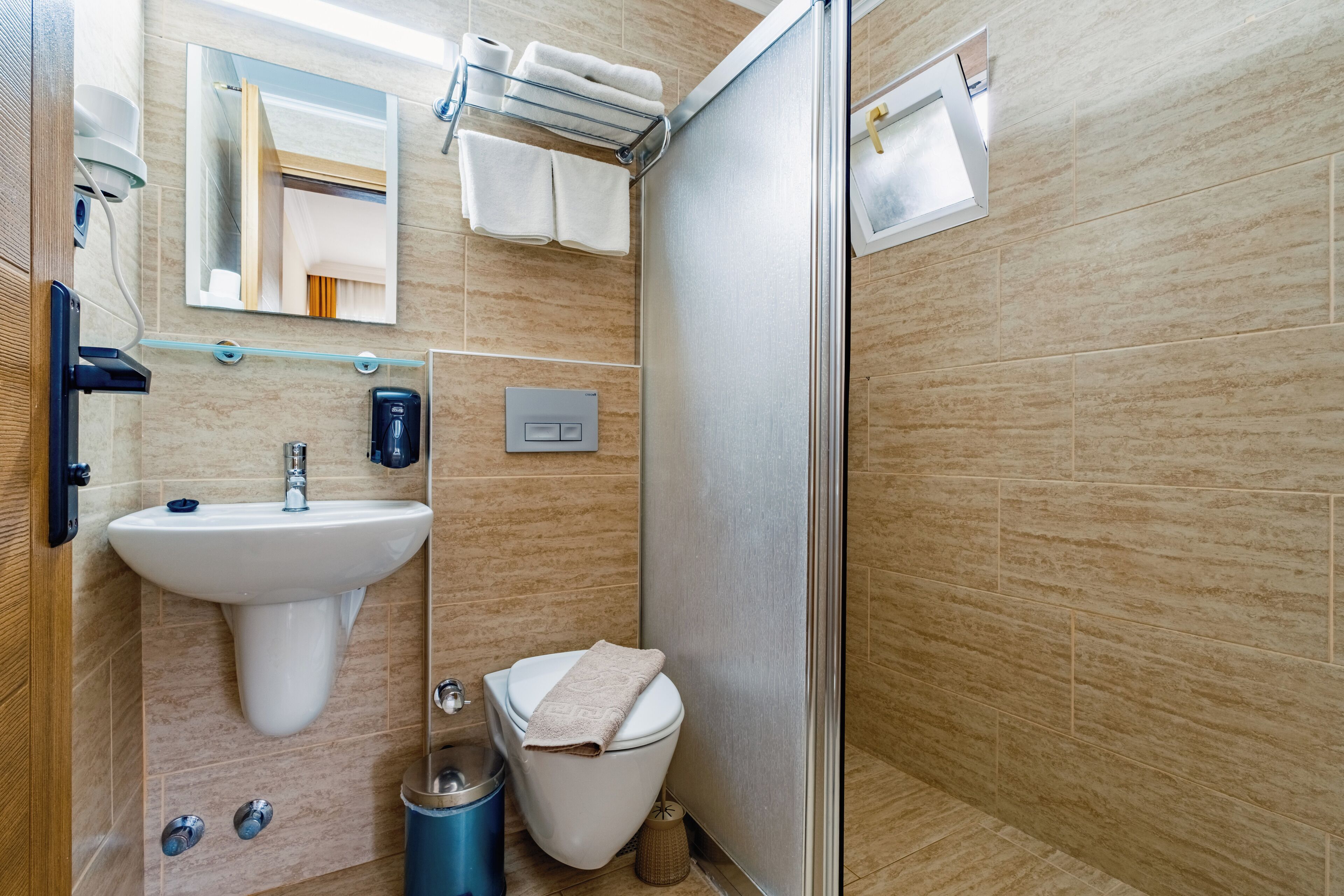 Une salle de bain moderne équipée d’un lavabo, de toilettes et d’une douche.