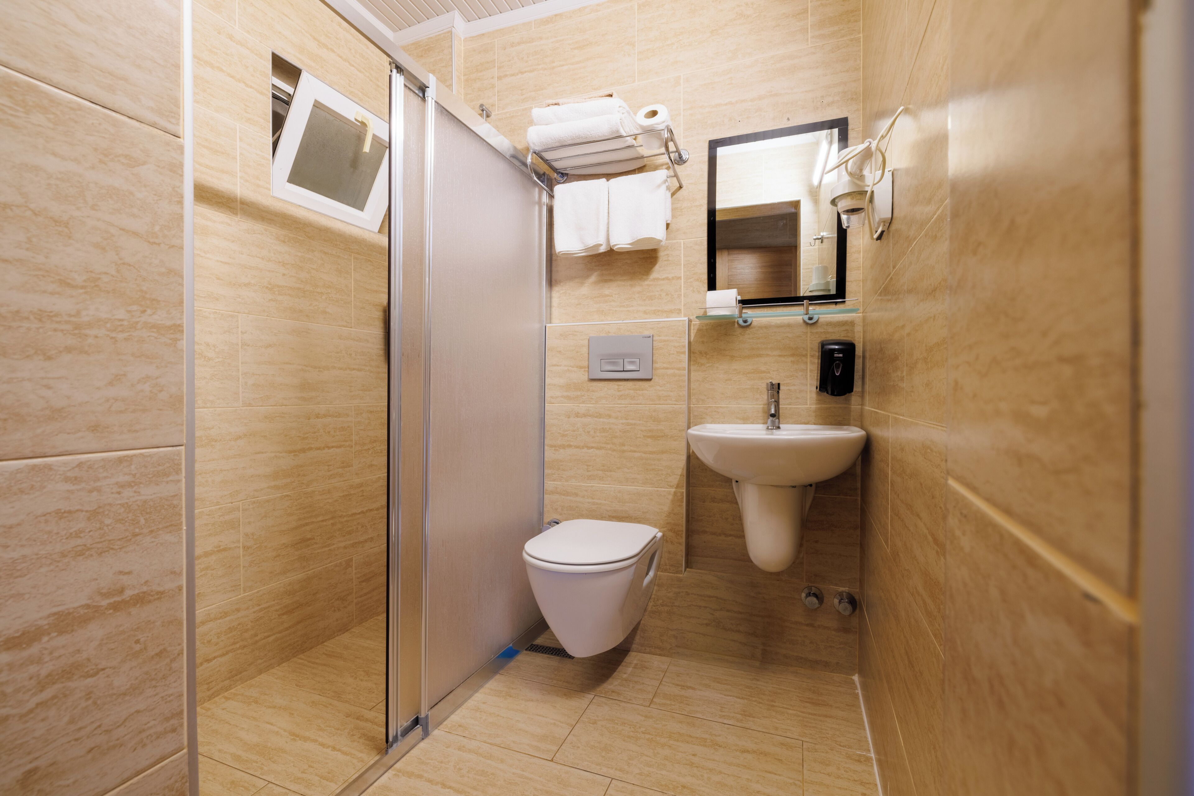 A modern bathroom with a toilet, sink, and shower.