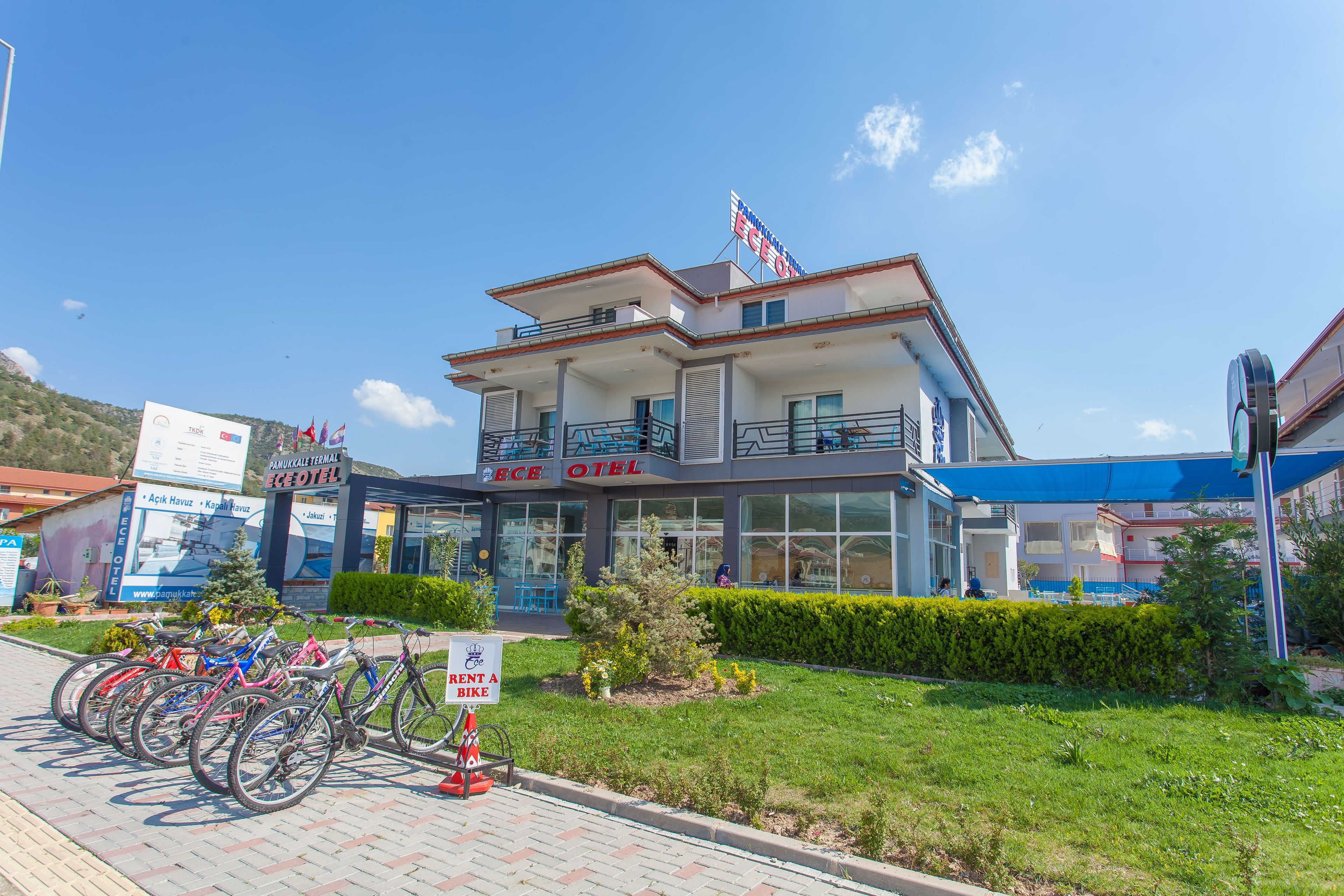 A hotel with a two-story structure, a balcony on the upper floor, and a sign indicating bike rental availability.