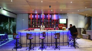 Una zona de bar con mostrador, taburetes y un refrigerador de Coca-Cola.