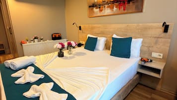 Una habitación de hotel con una cama, un cuadro, un radiador y un enchufe.