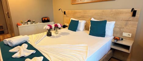 Una habitación de hotel con una cama, un cuadro, un radiador y un enchufe.