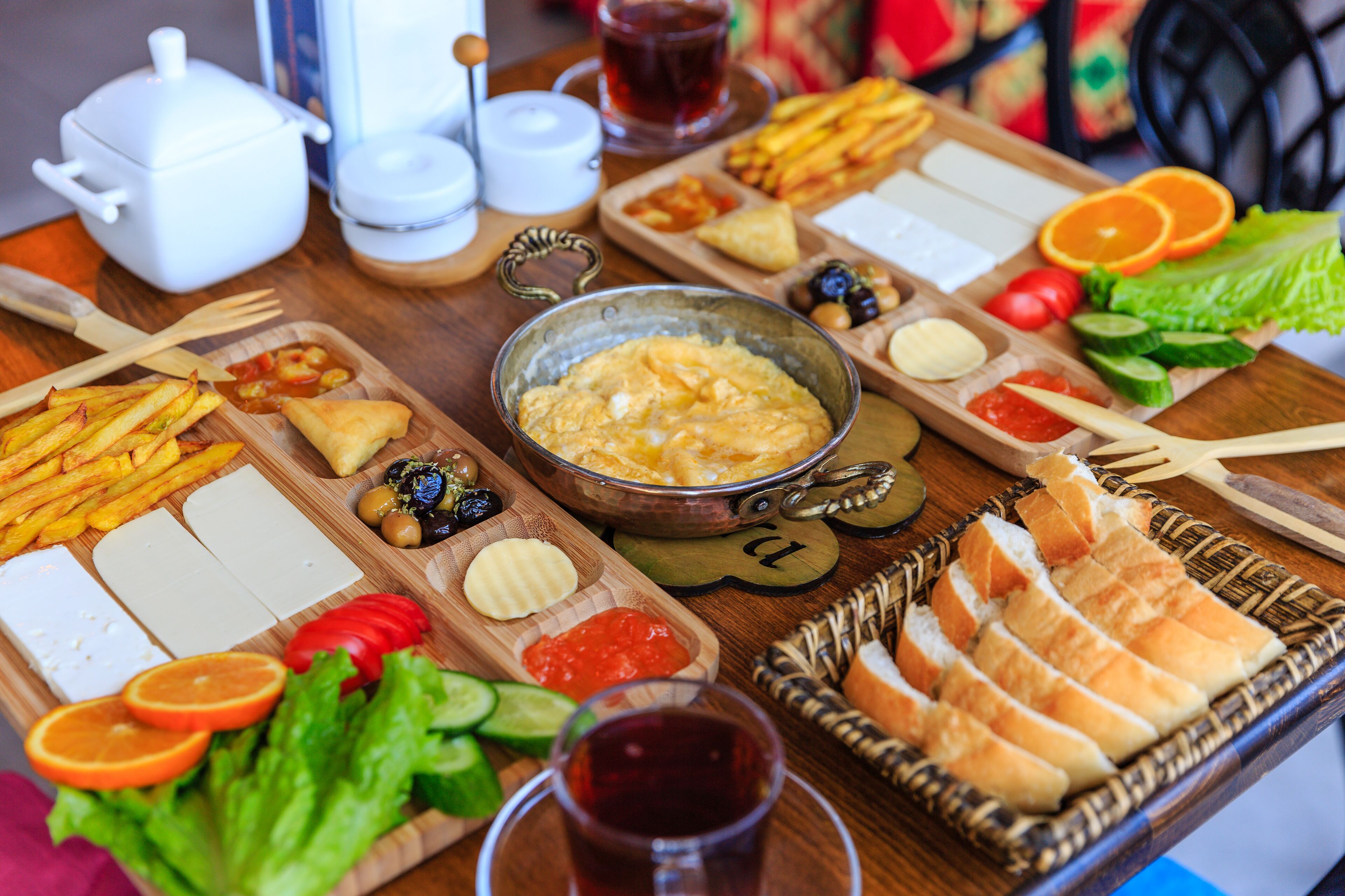 A table with various food items, including bread, cheese, and vegetables.
