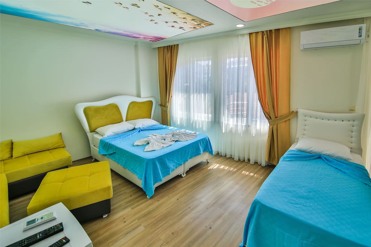 Une chambre d’hôtel avec un lit, un canapé, une table basse et un téléviseur.