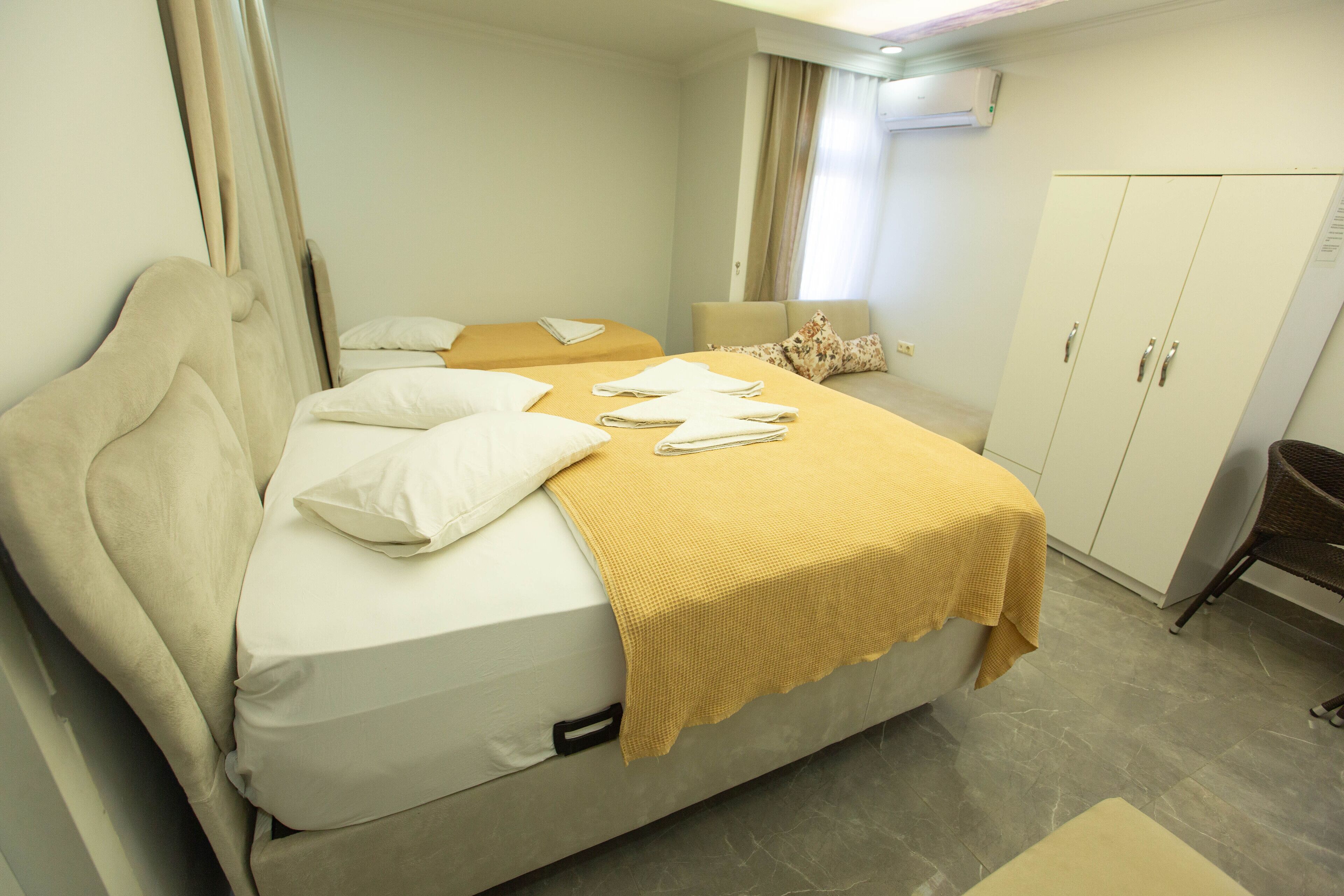 Una habitación de hotel con cama, armario y zona de estar.