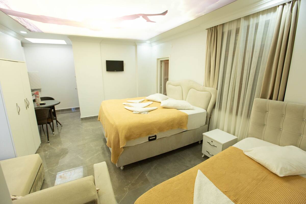 Une chambre d’hôtel comprenant un lit, une table de chevet et un bureau avec une chaise.