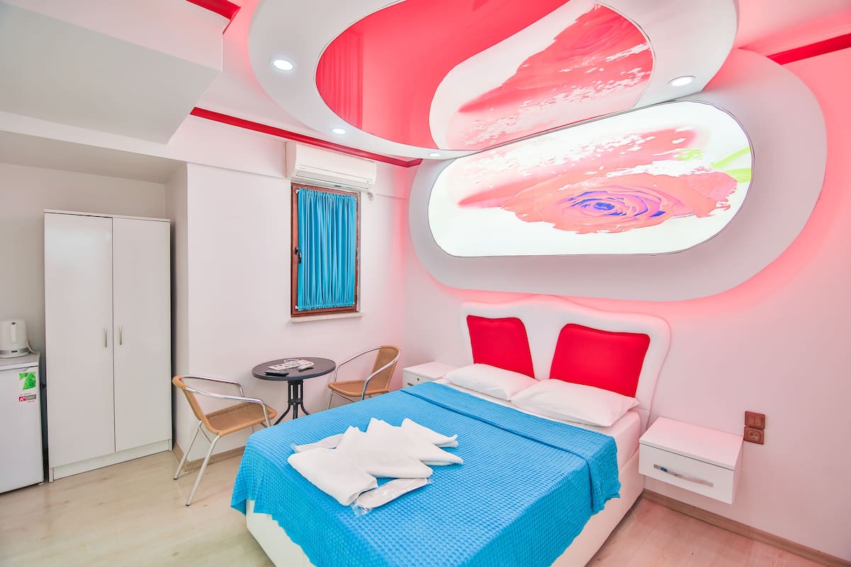 Une chambre d’hôtel moderne, équipée d’un lit, d’un bureau et d’une chaise.