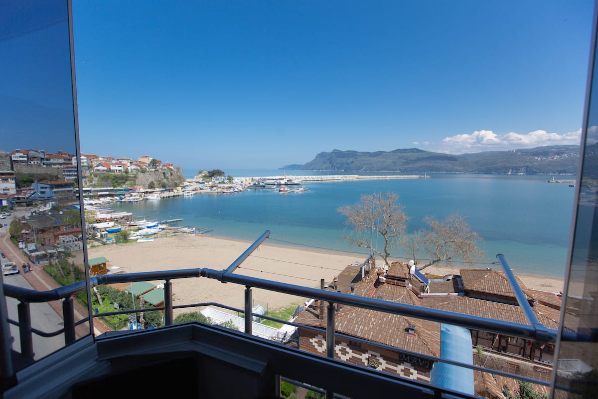 Une ville côtière avec une plage, des bateaux et un ciel bleu dégagé.