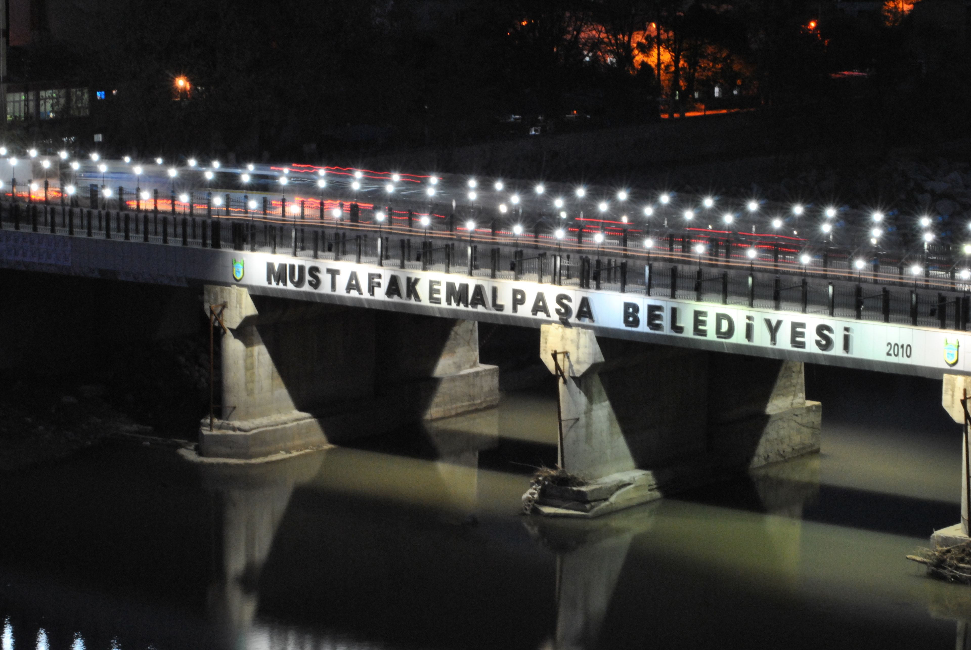 A bridge with lights and a sign that reads "MUSTAFAKEMAL PASA BELEDIYESI 2010".