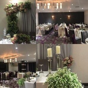 Ein Festsaal mit langen Tischen, floralen Dekorationen und modernen Leuchten.