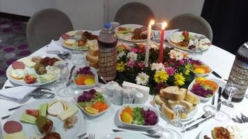 Una mesa de comedor preparada con diversos platos, velas y un centro de mesa decorativo.