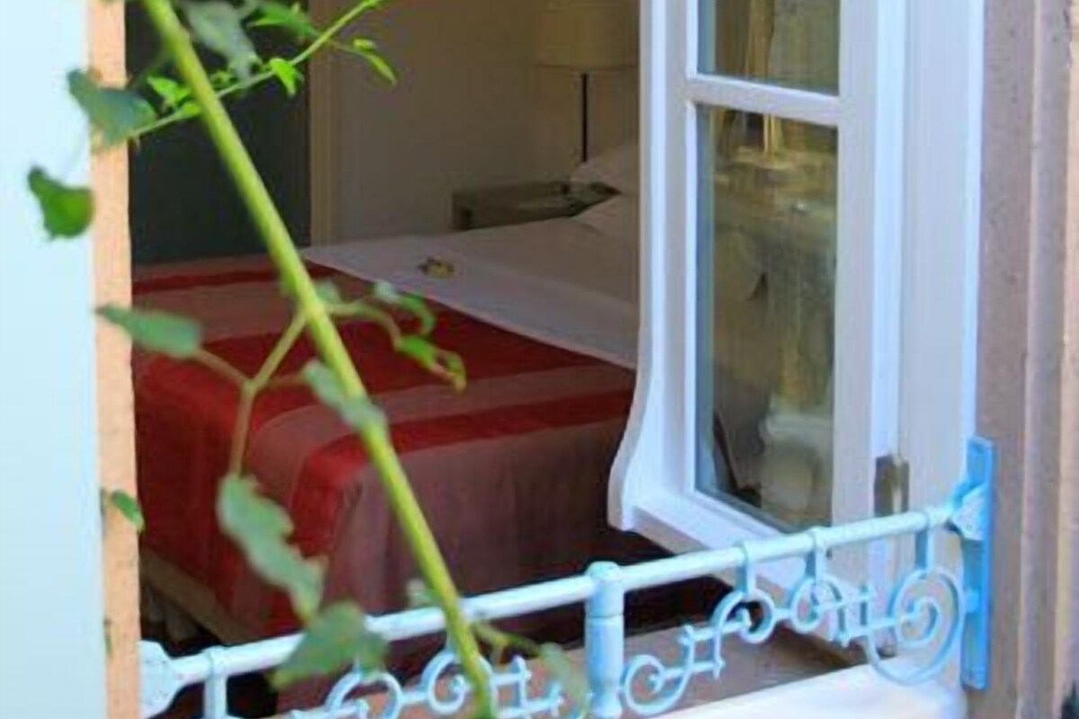 Una habitación con una cama, una ventana y una puerta.