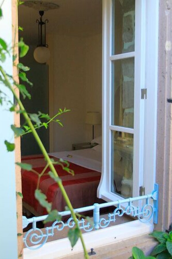 Una habitación con una cama, una ventana y una puerta.