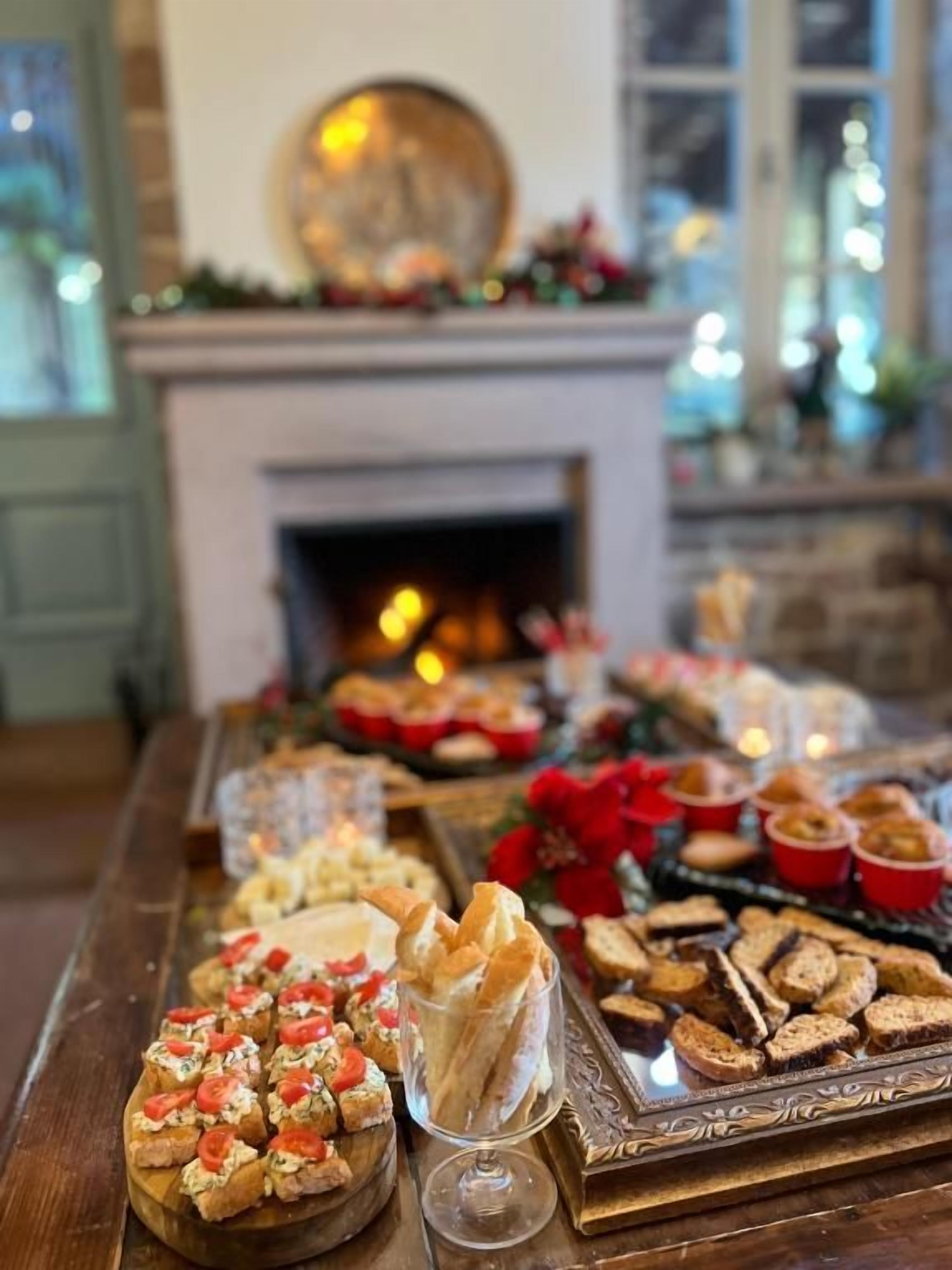 Una mesa de buffet con diferentes platillos y una chimenea al fondo.