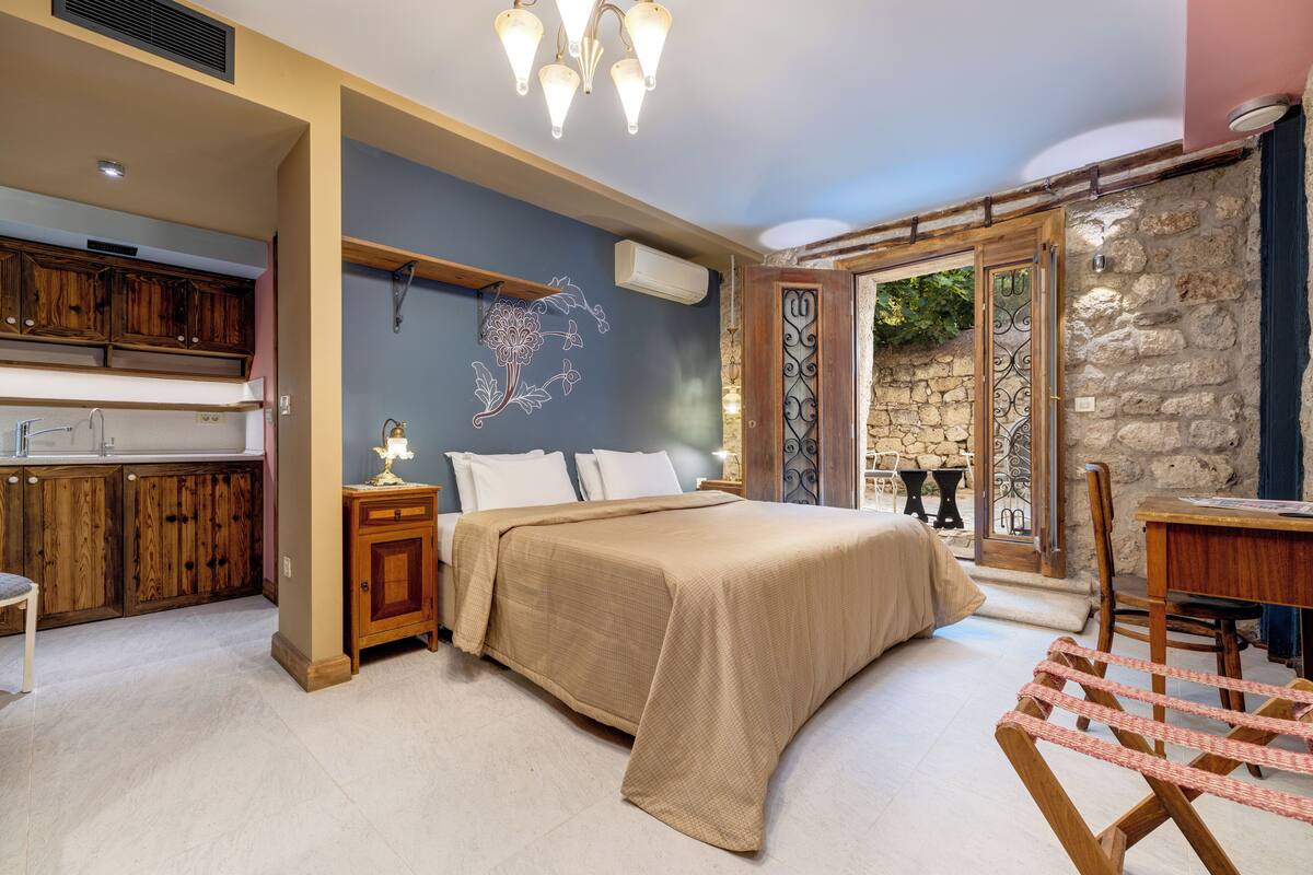 A bedroom with a bed, bedside tables, a desk, and a chair.