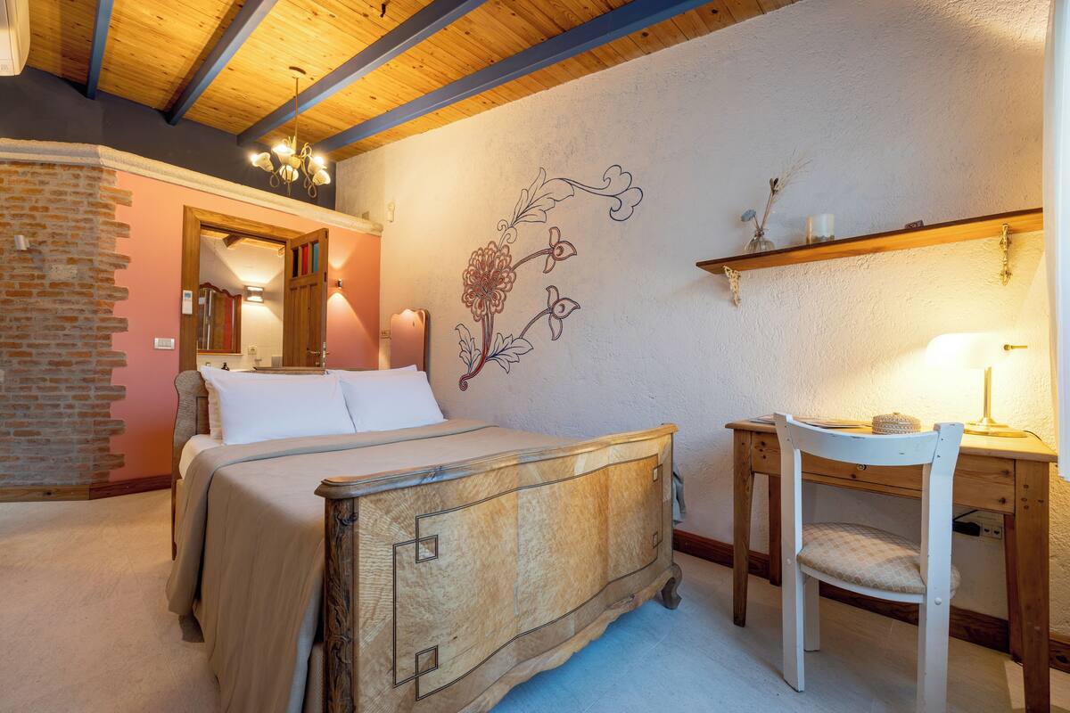 A bedroom with a wooden bed, a desk, and a chair.