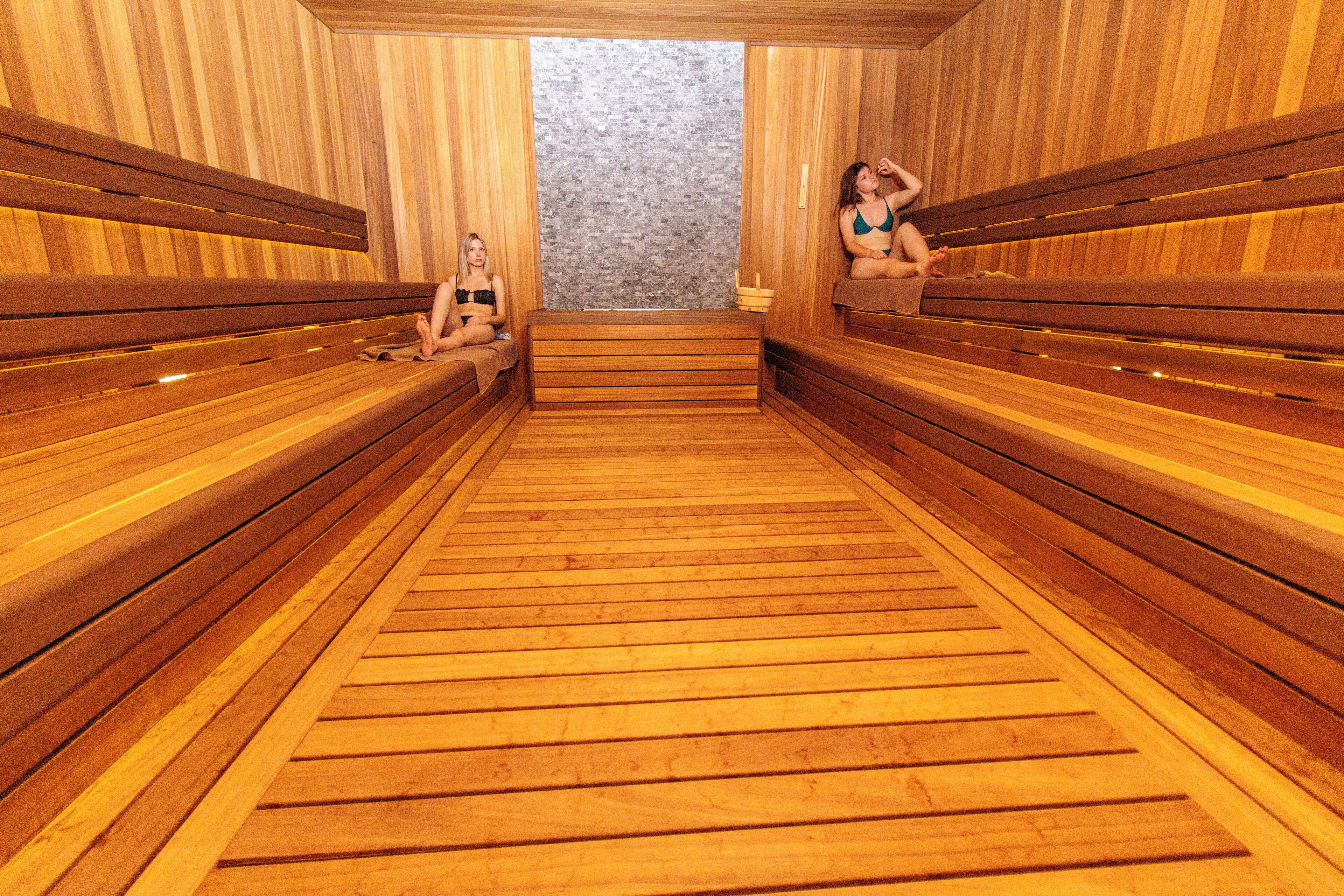 A sauna with wooden benches and a central bench.