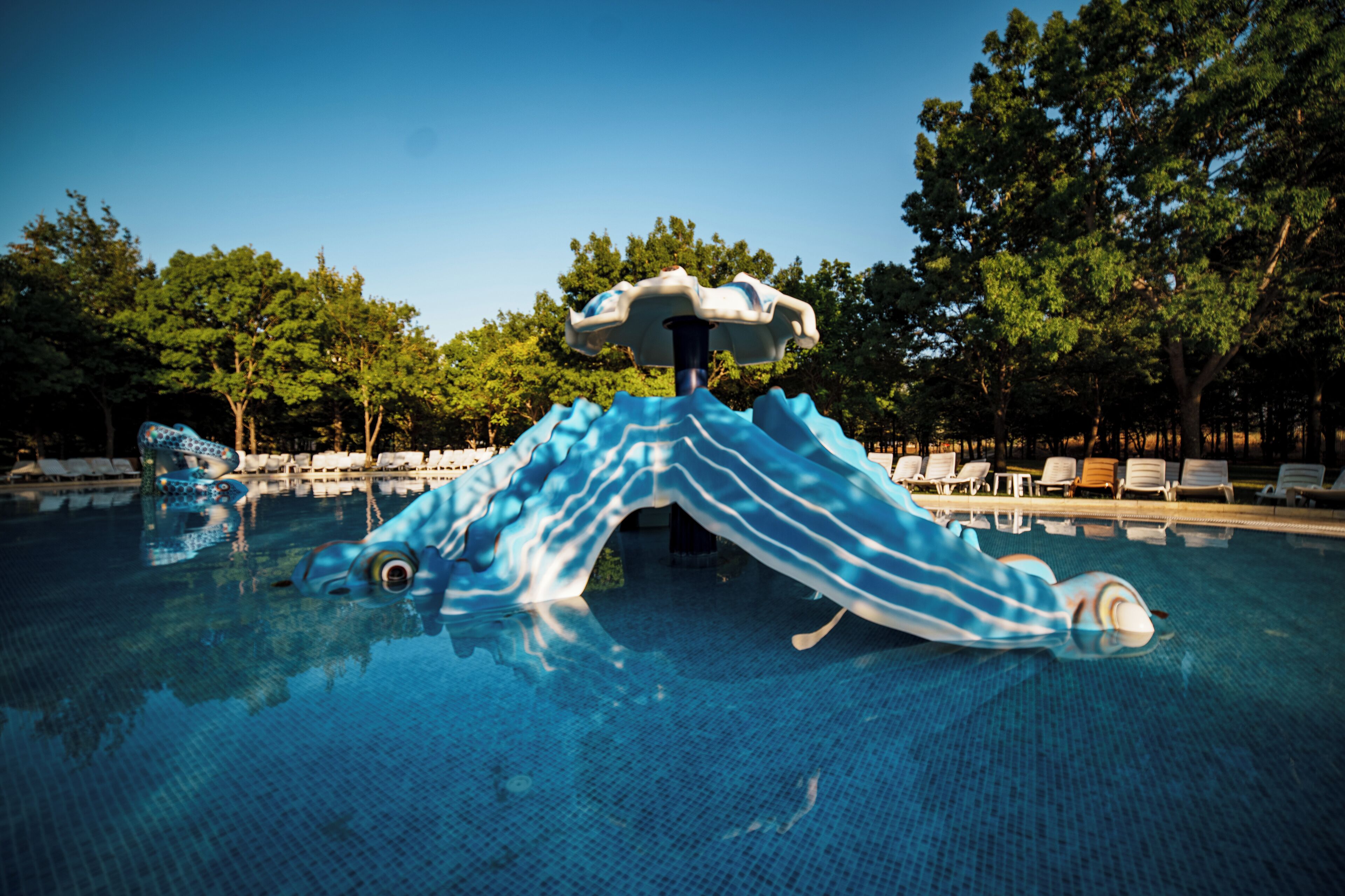 Una piscina con un tobogán de agua a rayas azules y blancas.