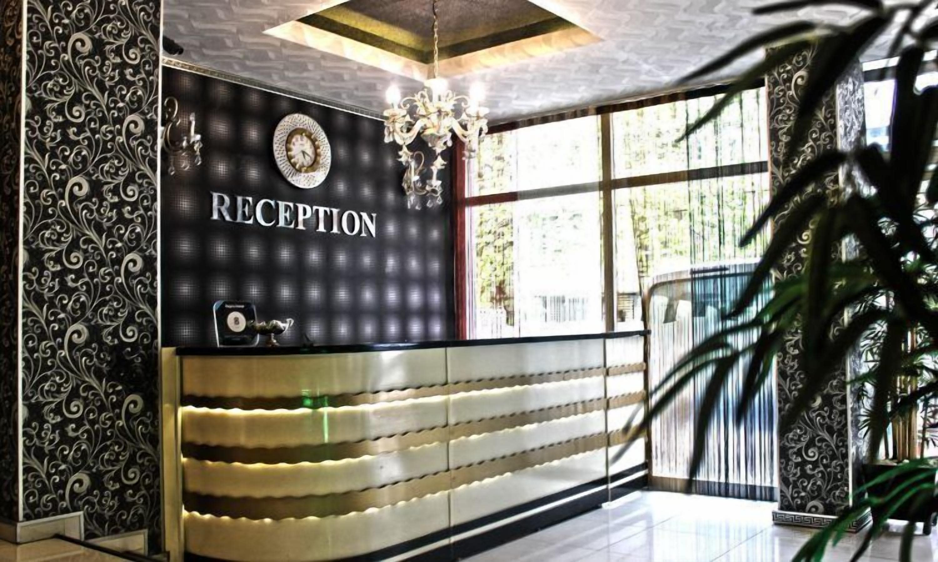 A reception area with a 'RECEPTION' sign, a clock, and a chandelier.