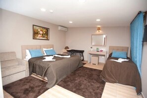 A hotel room with two beds, a sofa, a desk, and a mirror. - Riva's Club (Çekmeköy)