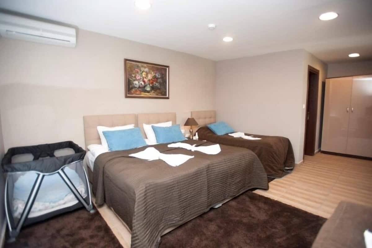 Un dormitorio con dos camas, un cuadro en la pared, un armario y un cubo de basura.