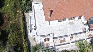 A building with a tiled roof, a balcony, and a stone facade. - Naftilos Skiathos (Skiathos)