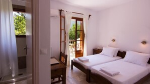 A bedroom with two beds, a wooden desk, and a chair. - Naftilos Skiathos (Skiathos)