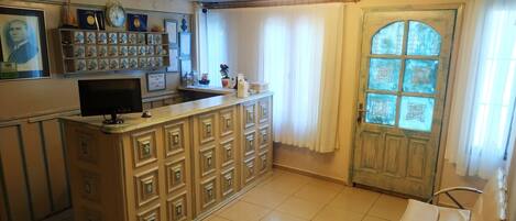 A reception area with a counter, a television, framed certificates, and a door with glass panels.