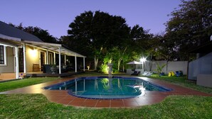 A backyard with a swimming pool, a covered patio, and a lawn. - Cu Boutique Guest House (Phalaborwa)