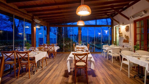 A dining area with tables and chairs, large windows, and a wooden ceiling. - Beta Home Lake House (Sapanca)