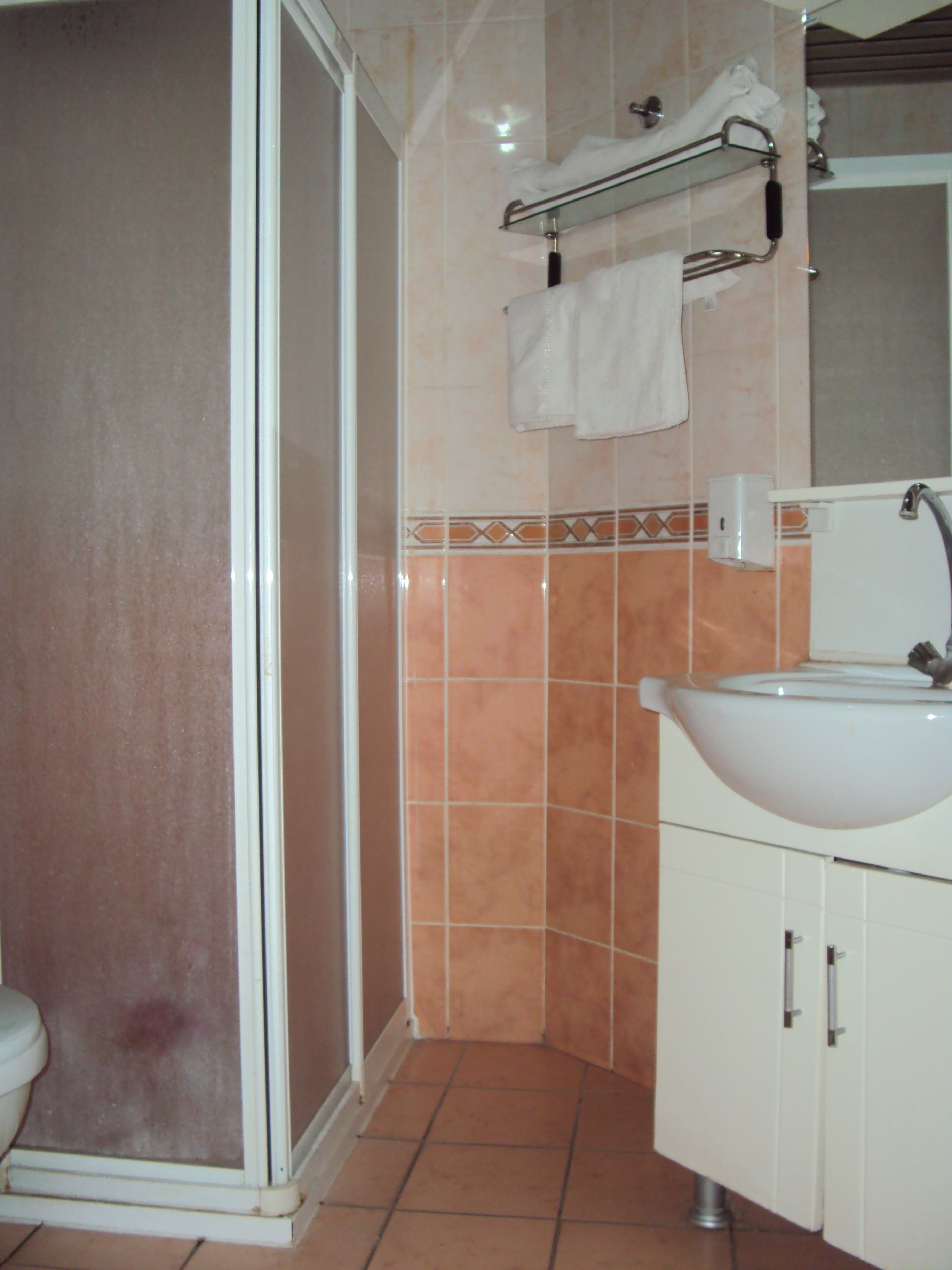 Un baño con ducha, inodoro y lavamanos.