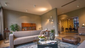 Ein modernes Wohnzimmer mit einer Couch, einem Couchtisch und einem Essbereich mit Stühlen und einem Tisch.