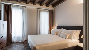 A hotel room with a large bed, wooden floor, and a wardrobe. - MYSWEETPLACE - Fondamenta Moro Apartment (Venice)