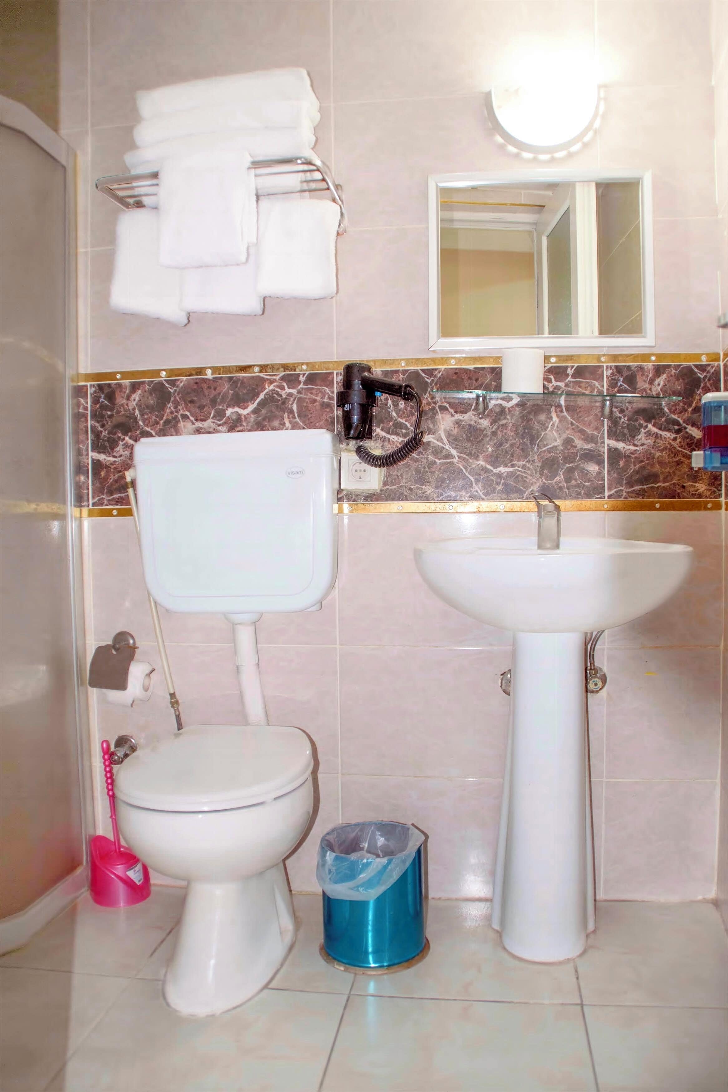 Ein Badezimmer mit Toilette, Waschbecken und Handtuchhalter.