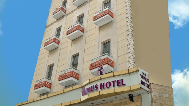 Hotel de vários andares com varandas e um céu claro.