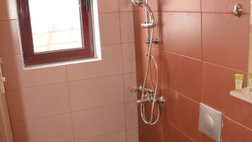 A bathroom with a shower, toilet, and sink.