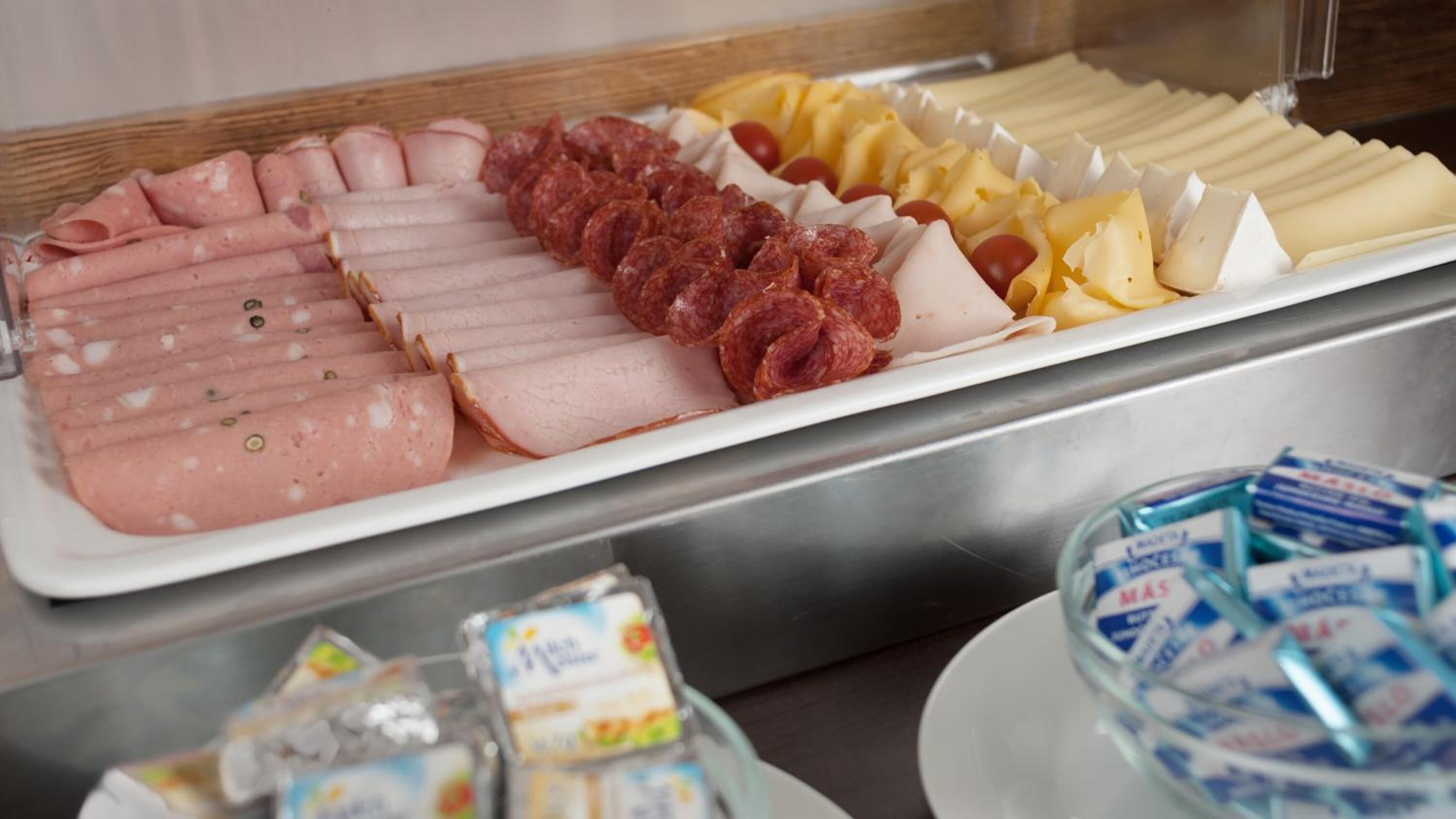 Ein Buffet mit verschiedenen Fleisch-, Käse- und Wurstwaren sowie Beilagen.