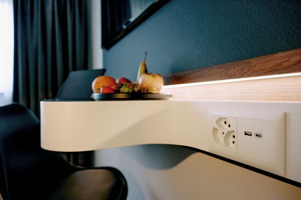 A wall-mounted shelf with fruits and a lamp, a power outlet, and a USB port.