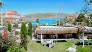 Une propriété située sur la côte, dotée d’un espace extérieur avec une toiture de chaume, offrant une vue sur la mer et présentant une architecture traditionnelle.