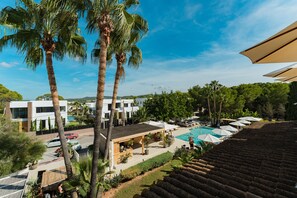 A resort with a swimming pool, palm trees, and modern buildings. - Hotel Boutique & Spa Las Mimosas Ibiza (Sant Josep de sa Talaia)