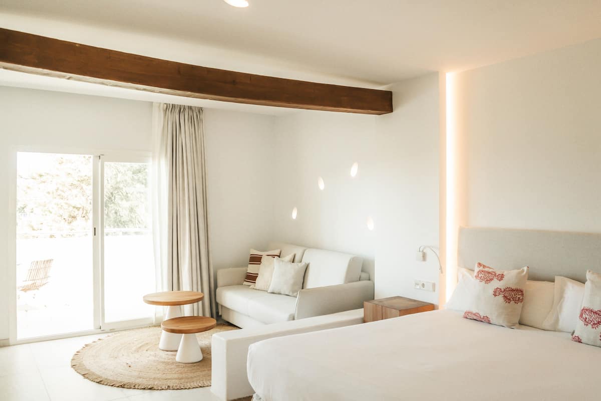 Un dormitorio moderno con una cama grande, un sofá y una mesa de comedor.