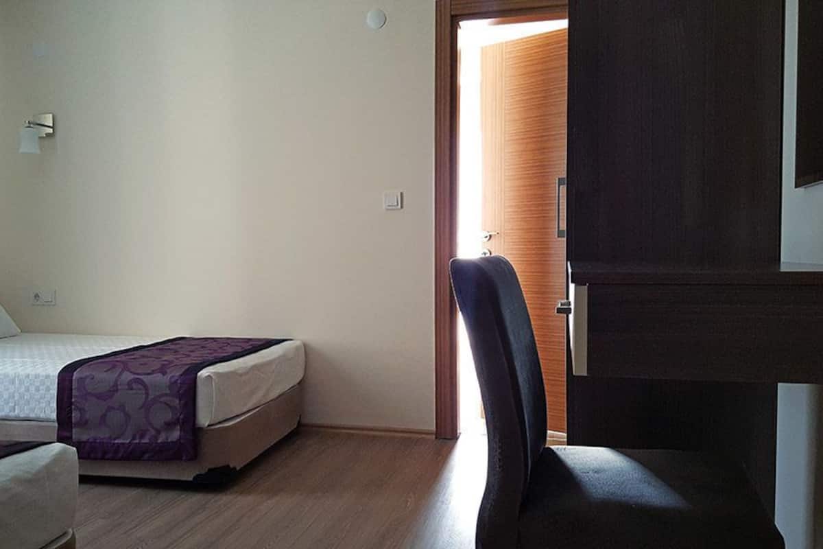 Un dormitorio con cama, una silla y un armario.