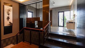 A modern interior with a staircase, wooden flooring, and a brick wall with artwork. - Leedon Motel (Kaohsiung)