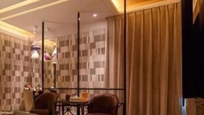A hotel room with a checkered wall pattern, a bed, two armchairs, a table, and a large mirror. - Leedon Motel (Kaohsiung)