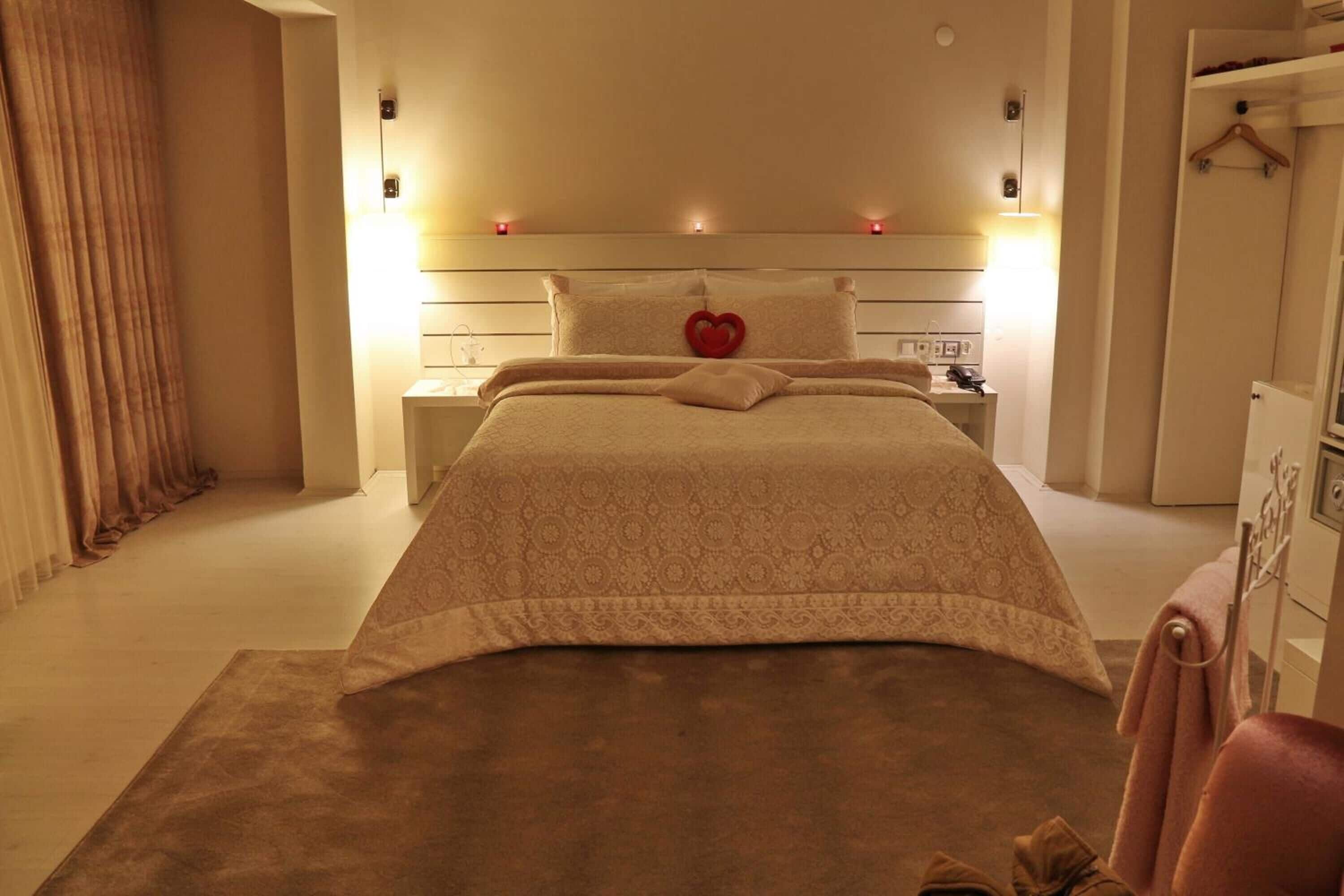 Ein ordentlich eingerichtetes Schlafzimmer mit einem großen Bett, Nachttischen, einem Kleiderschrank und einem Hängehandtuchhalter.